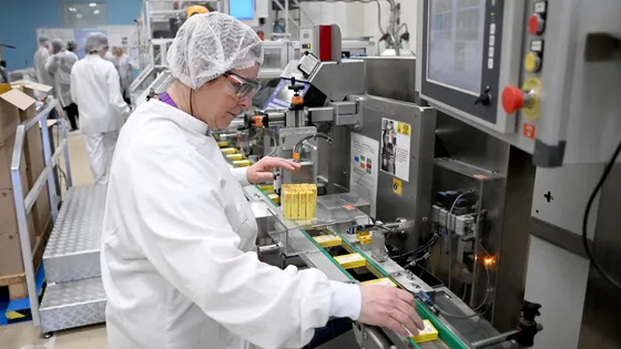 Photo d'une conductrice de ligne automatisée sur l'une des chaînes de mise en conditionnement des boites de Doliprane à l'usine Sanofi de Lisieux, dans le Calvados.