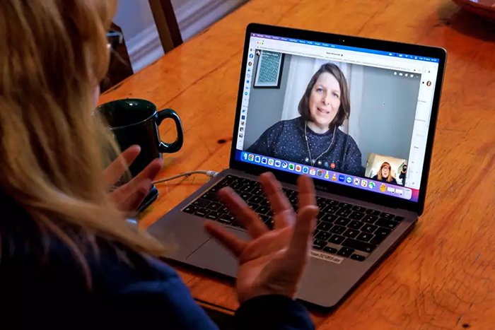 Photo de Chantal Guy, vue de dos, en conversation avec Marie-Hélène Voyer qu'elle voit à l'écran de son ordinateur.