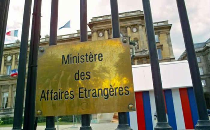 Photo d'une plaque métallique dorée posée sur la porte grillagée d'une ambassade. On y lit: «Ministère des Affaires étrangères».