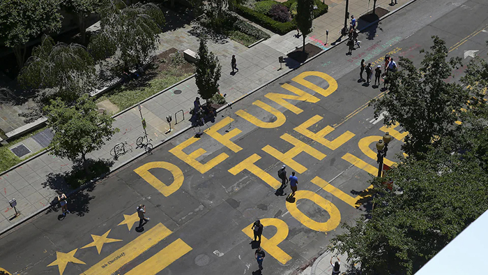 Photo. Les mots « Defund The Police » (Réduisez le budget de la police) ont été peints sur la rue menant à la Maison-Blanche, à Washington.