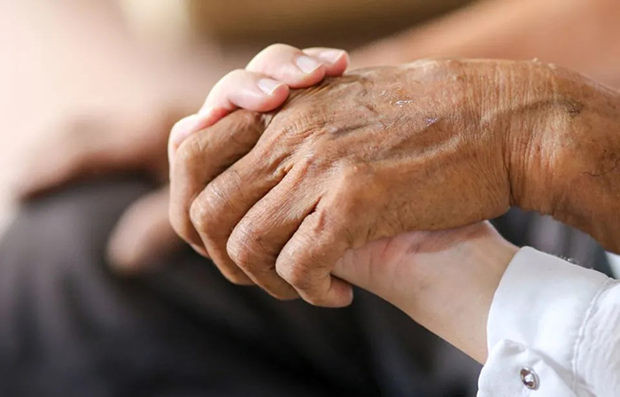 Photo d'une main qui tient la main d'une personne âgée.