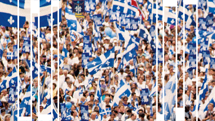 Photo d'une foule arborant de nombreux drapeaux du Québec.