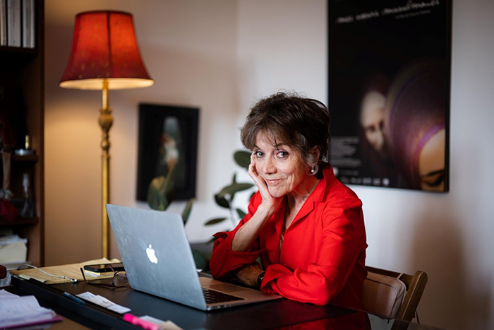 Portrait photo de Francine Pelletier assise à un bureau devant un ordinateur.