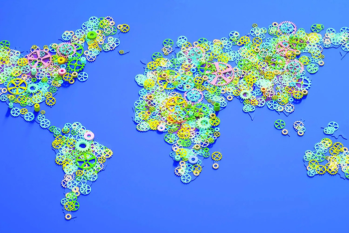 Photo. Carte du monde reproduite à l'aide d'une multitude de petits engrenages de plastique colorés.