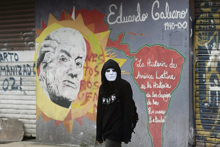 Photo. Un manifestant passe devant une peinture murale du journaliste uruguayen Eduardo Galeano.