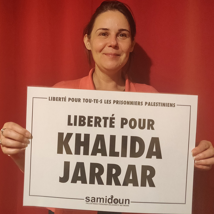 Photo de Gwenola Ricordeau tenant une affiche en soutien à KHalida Jarrar.