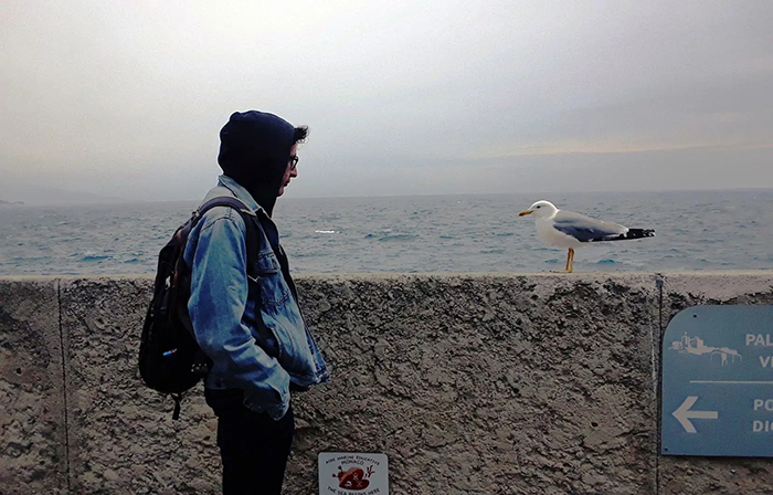 Portrait photo d'Émilien Bernard posant devant une mouette.