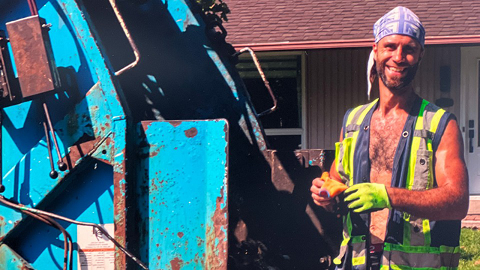 Photo de Simon Paré-Poupart derrière un camion de poubelles.