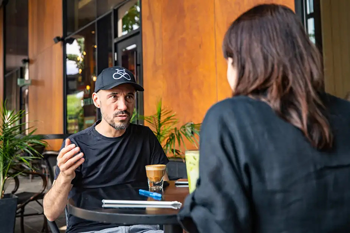 Photo de Jean-Philippe Pleau assis à une table avec la journaliste Ariane Krol.