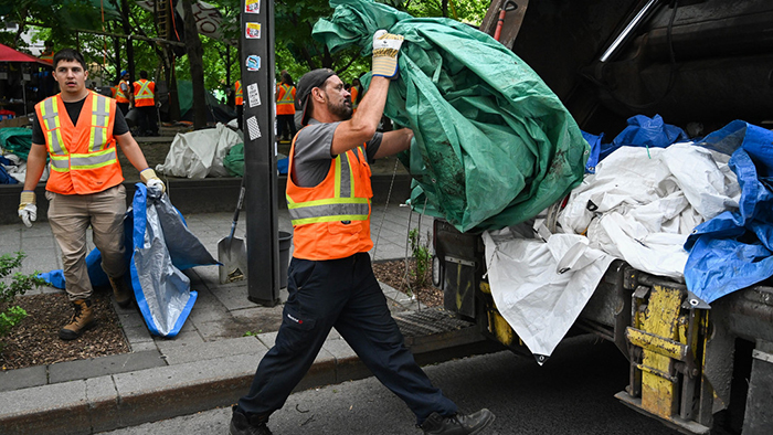 Photo de vidangeurs jettant des déchets dans un camion.