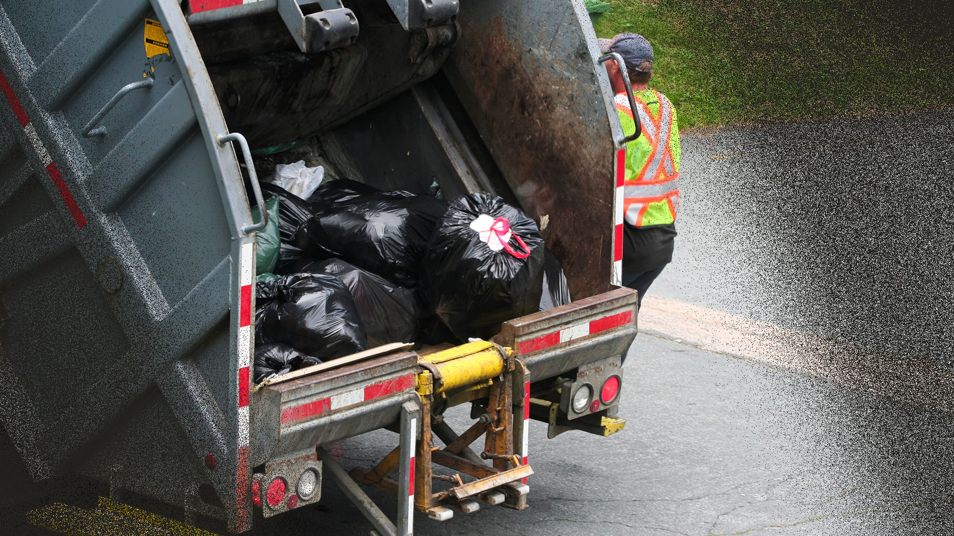 Photo d'un camion de poubelles avec un vidangeur à l'arrière.