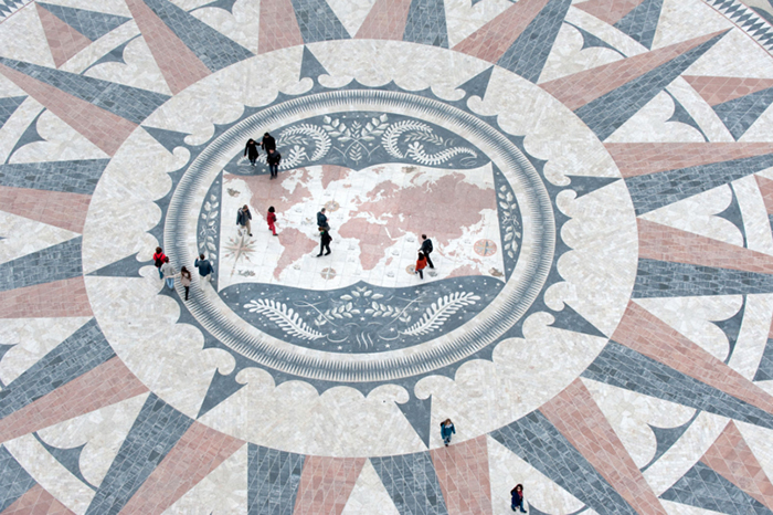 Photo d'une grande place publique au centre de laquelle se trouve une mosaïque illustrant une carte du monde.