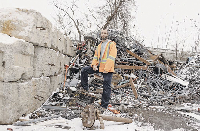 Photo de Simon Paré-Poupart devant une pile de déchets.