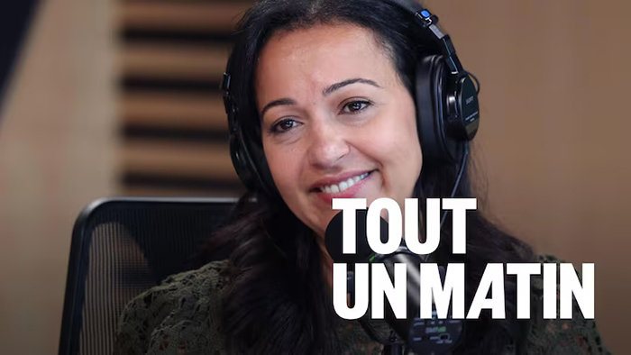 Portrait photo de Ruba Ghazal devant un micro de radio avec le titre de l'émission «Tout un matin».