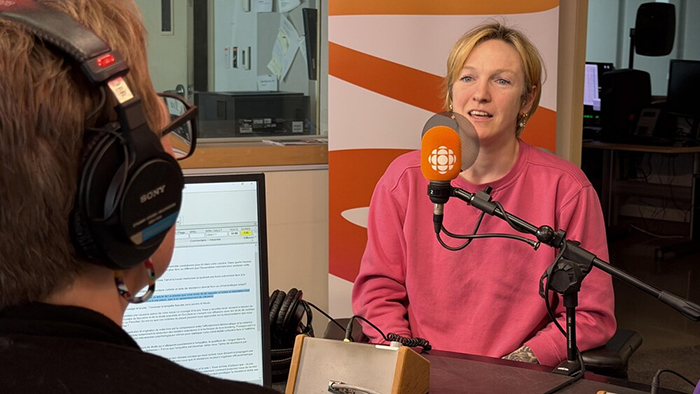 Photo de Catherine Dorion devant un micro de radio.