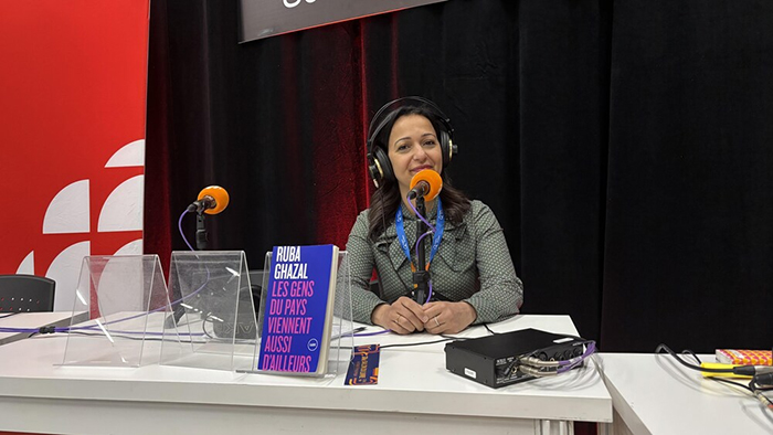Photo de Ruba Ghazal devant un micro de radio.