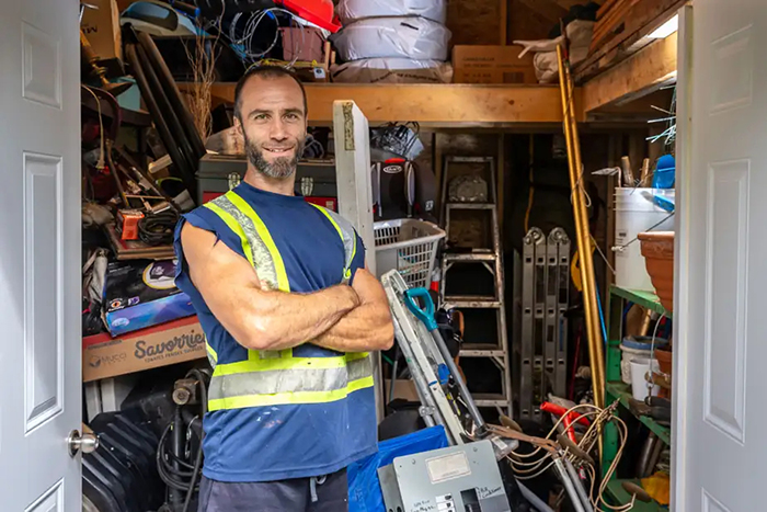 Photo de Simon Paré-Poupart posant devant le contenu de sa remise.